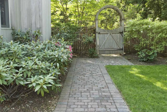 Brick walkway and wooden gate with arbor