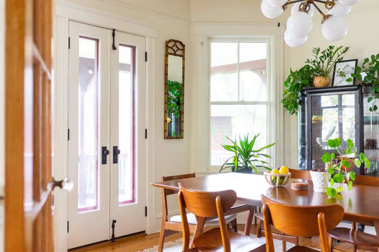 Dining room with wooden table and surrounded by white walls and houseplants