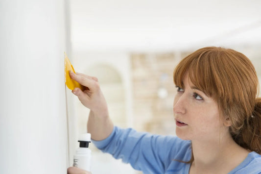 Woman patching drywall with putty knife