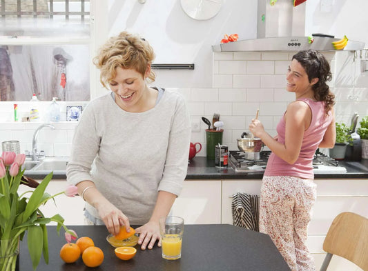 Female friends making breakfast in kitchen